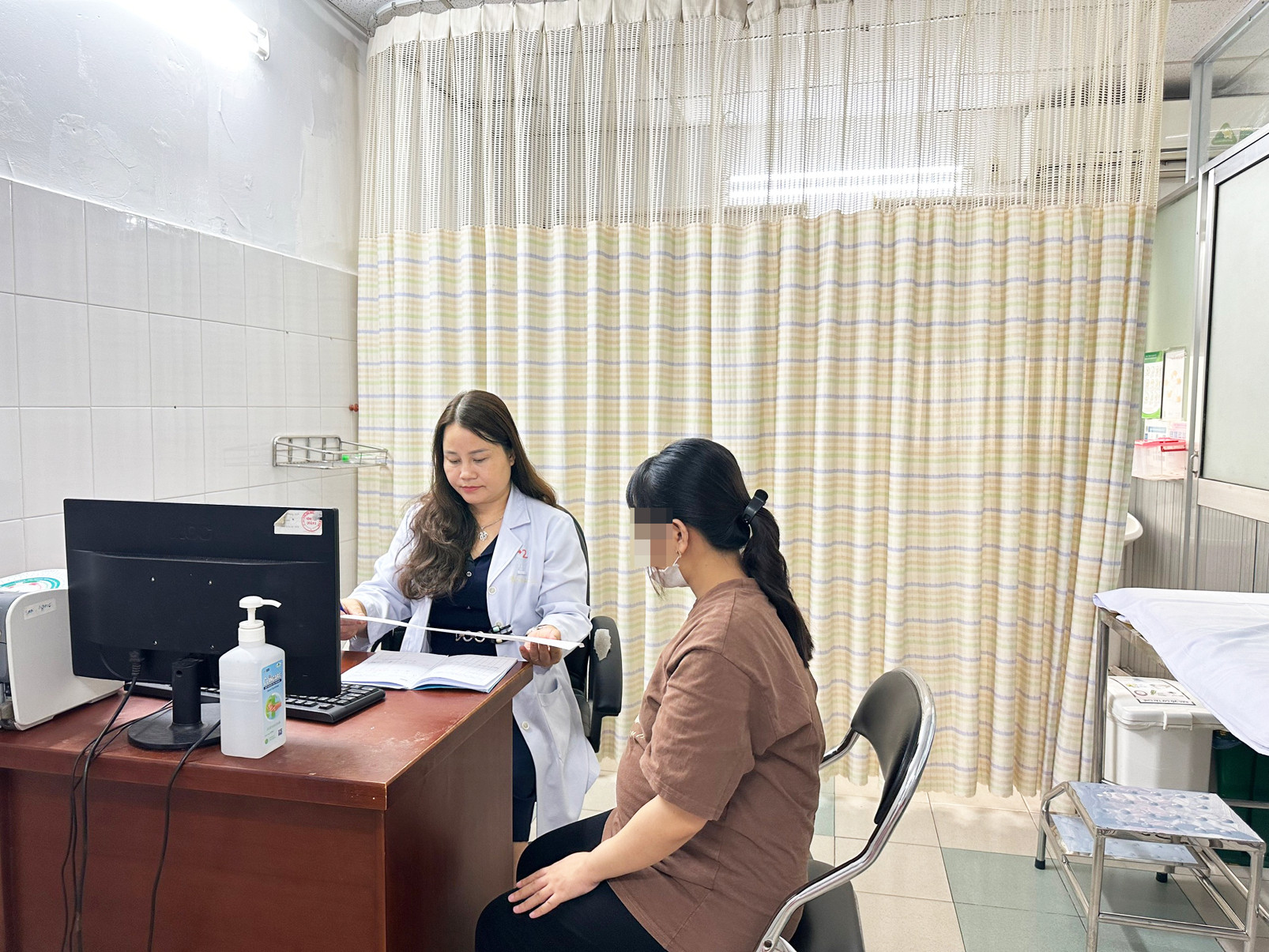 Bác sĩ Nguyễn Hương Lan đang tư vấn cho một thai phụ về tầm soát sức khỏe thai kỳ (ảnh chụp tại Bệnh viện Lê Văn Thịnh ngày 19/6) - ẢNH: T.HUYỀN